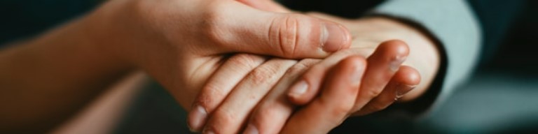 Deux mains tenant délicatement la main d'une autre personne, suggérant le réconfort ou le soutien - une image qui incarne l'esprit du service à la personne et de l'engagement dévoué dans l'emploi. Photo pour signifier l'utilisation d'un ATS pour améliorer l'expérience candidat dans le contexte des emplois du service à la personne
