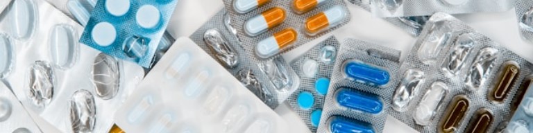 Plaquettes assorties de pilules et de gélules de différentes couleurs disposées sur une surface plane, mettant en évidence les innovations en biotechnologie et le besoin croissant de recrutement dans le secteur de l'emploi pharmaceutique. Visuel concernant l'utilisation d'un logiciel ATS de recrutement