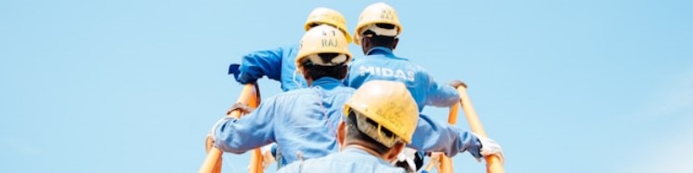 Quatre travailleurs en uniforme bleu et casque jaune grimpent à une échelle dans un ciel bleu clair, illustrant le travail d'équipe exigeant dans le BTP, un secteur clé pour tout recruteur utilisant un logiciel de recrutement. Photo symbolisant l'utilisation d'un Logiciel ATS de recrutement pour améliorer l'expérience candidat